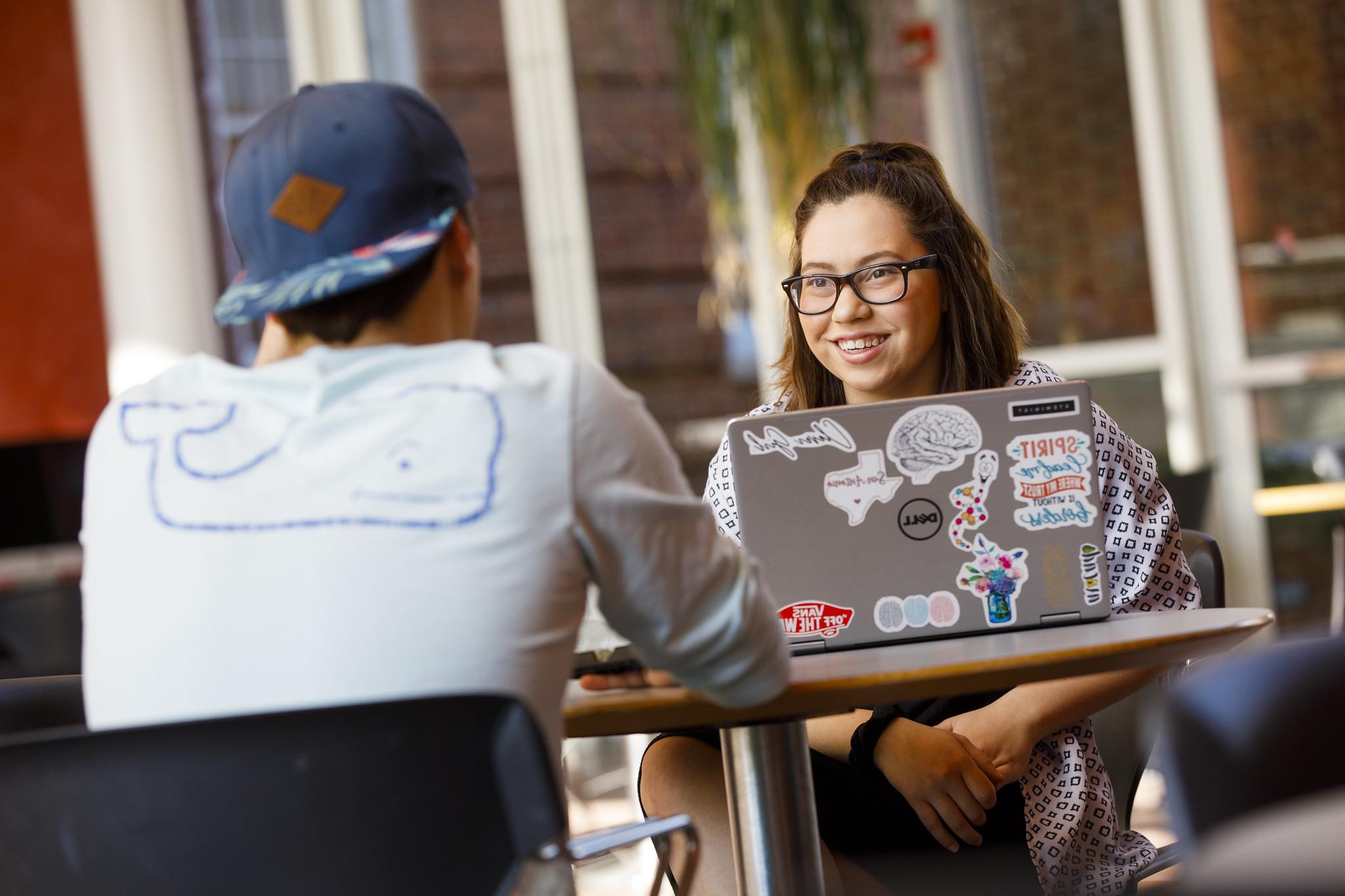 Students sitting at a table with computers